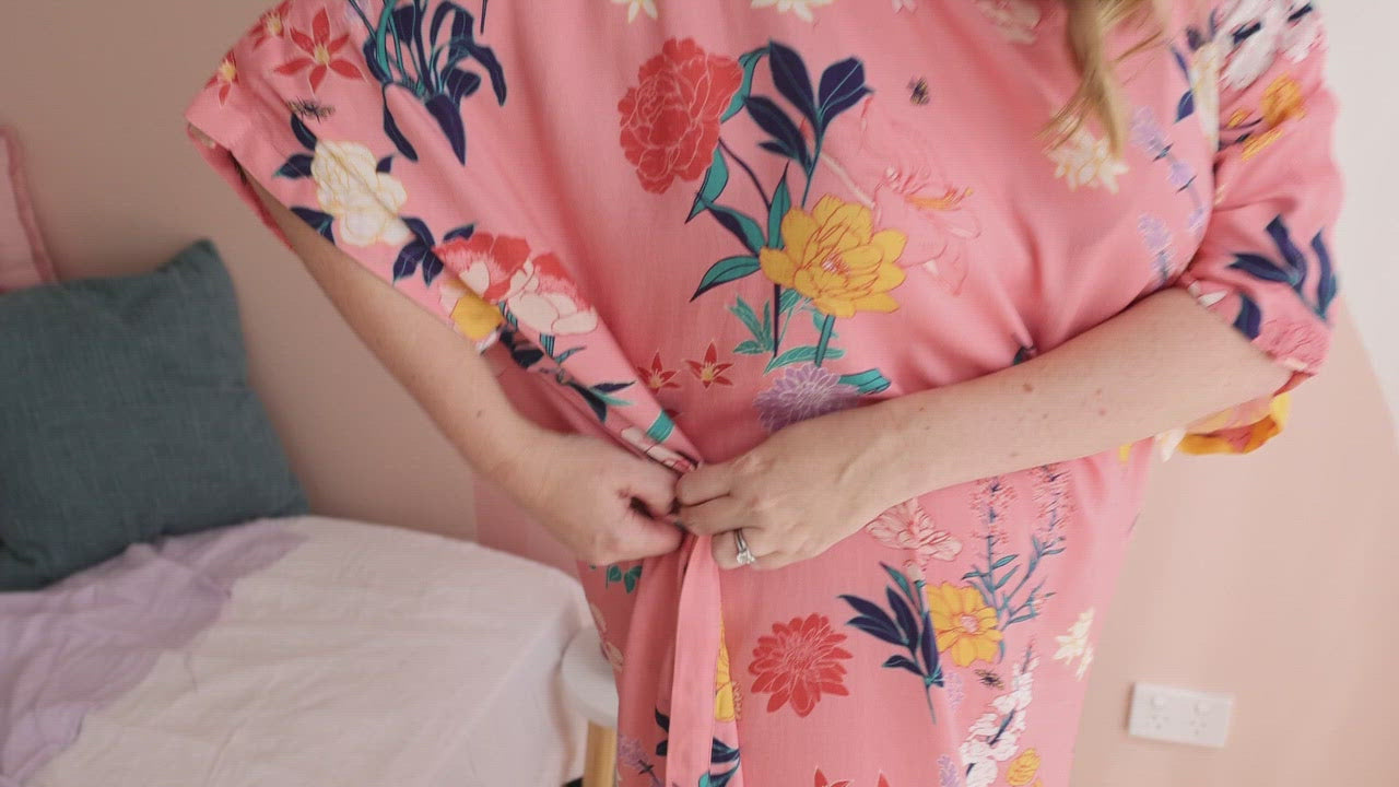 video showing a woman opening the side of her pink floral adaptive dress