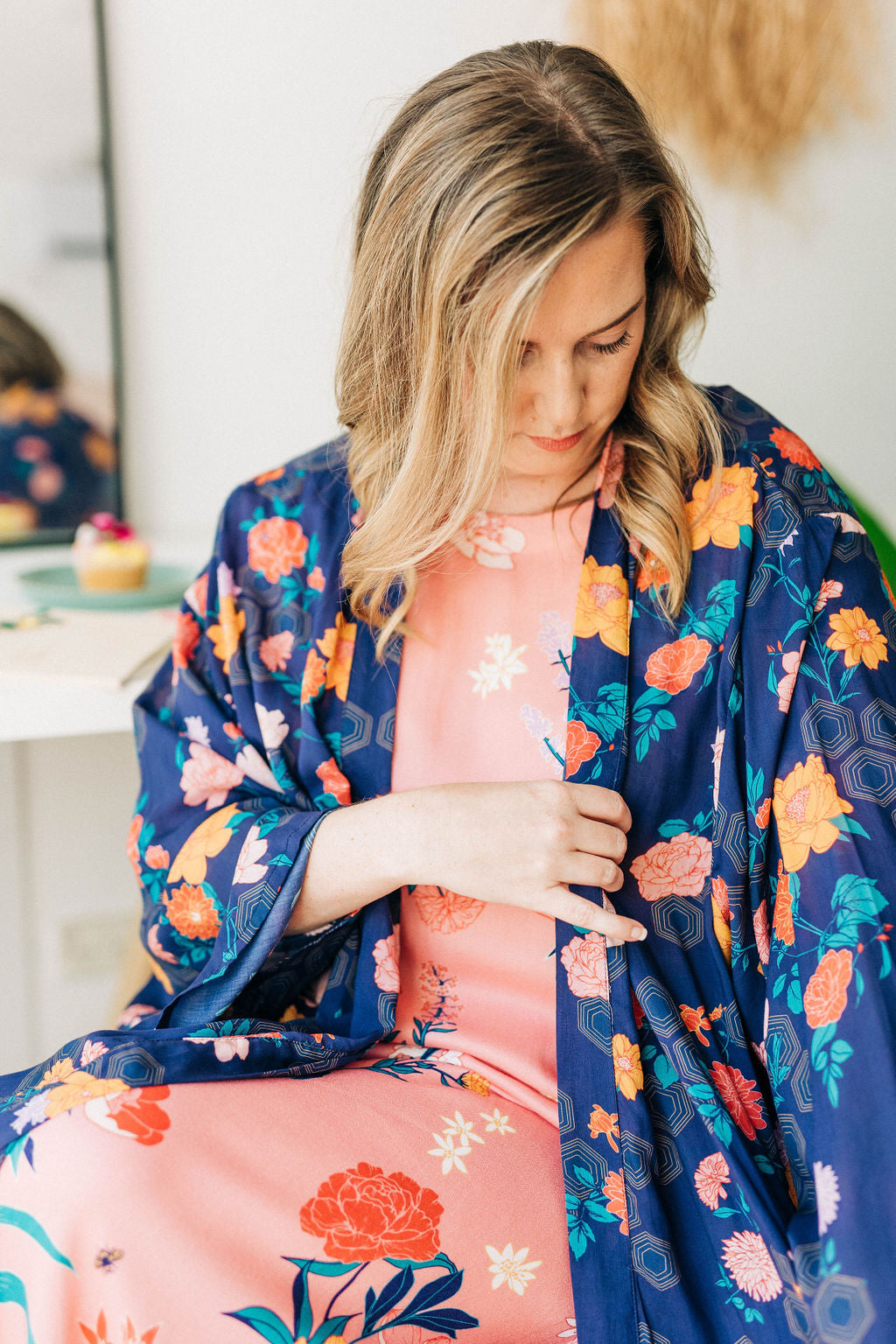 woman looking at the sleeve of her limonata navy floral print chimono robe