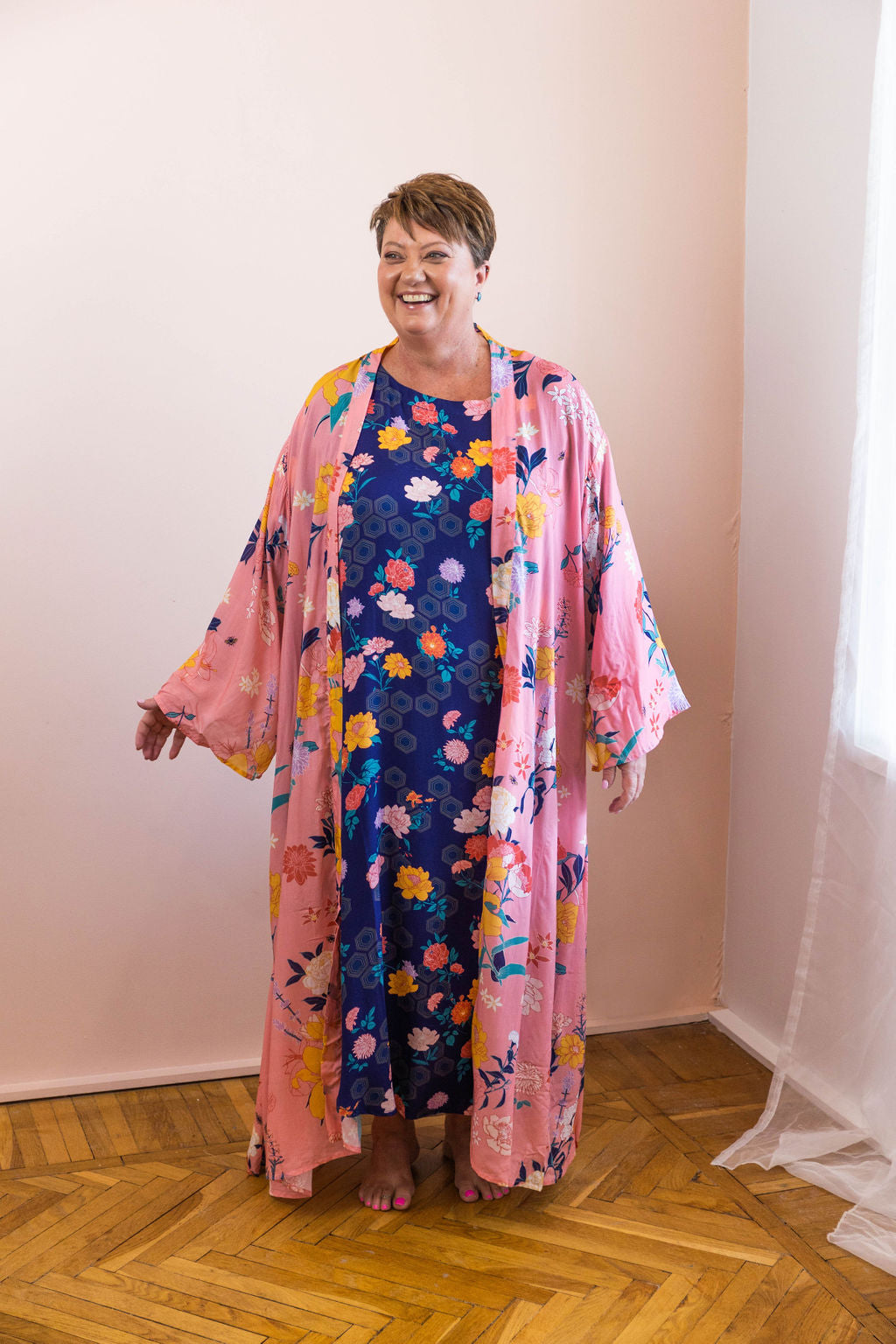woman wearing pink fiorella floral chimono robe with navy dress