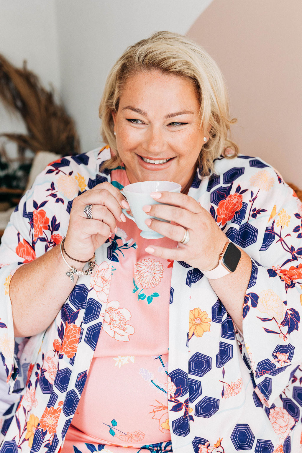 woman in bright dress and colourful adaptive dressing gown drinking a cup of tea
