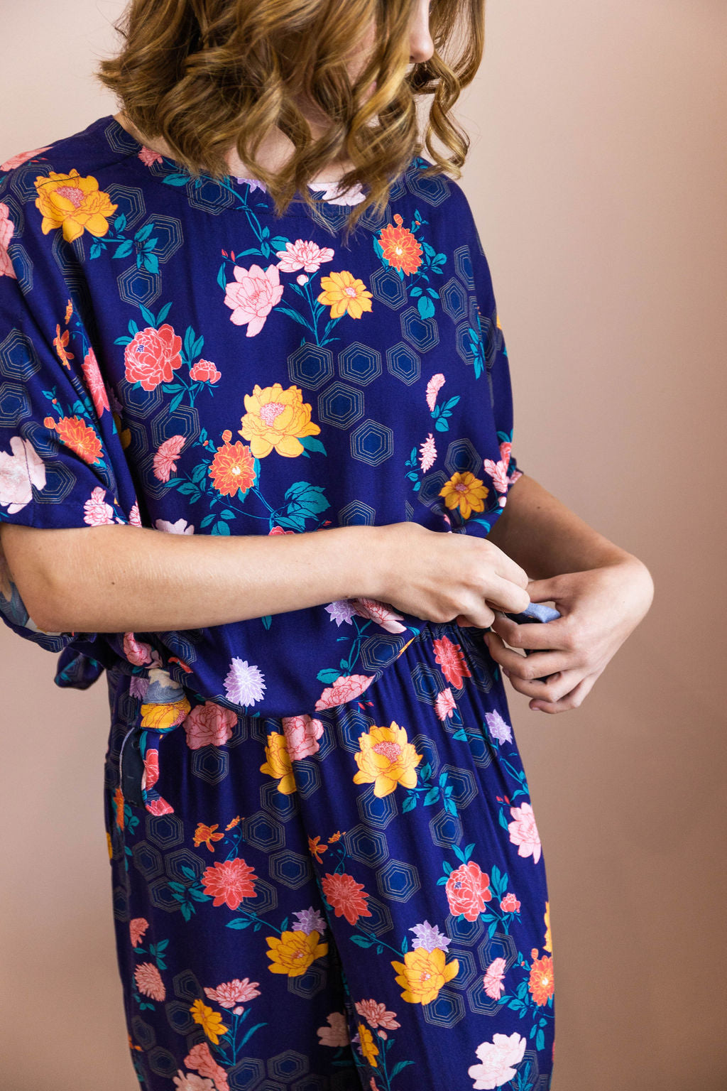 woman tying a knot wearing matching limonata adaptive navy geometrica print set top and palazzo pants