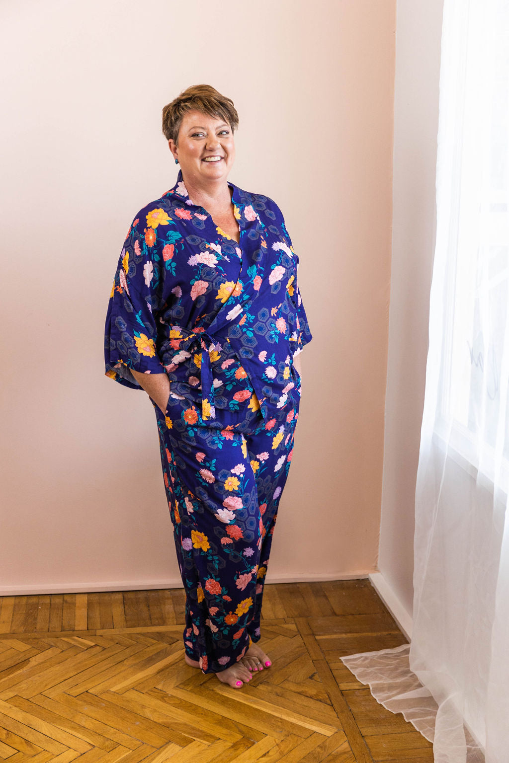 woman wearing matching navy geometrica floral print adaptive wrap top and pants