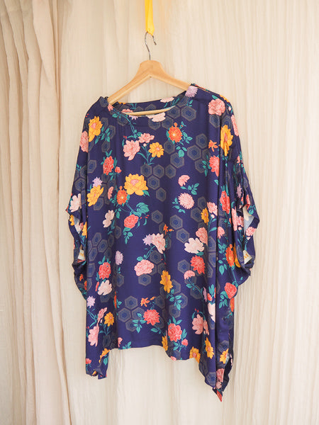 limonata navy geometric and floral print adaptive top hanging on a coathanger