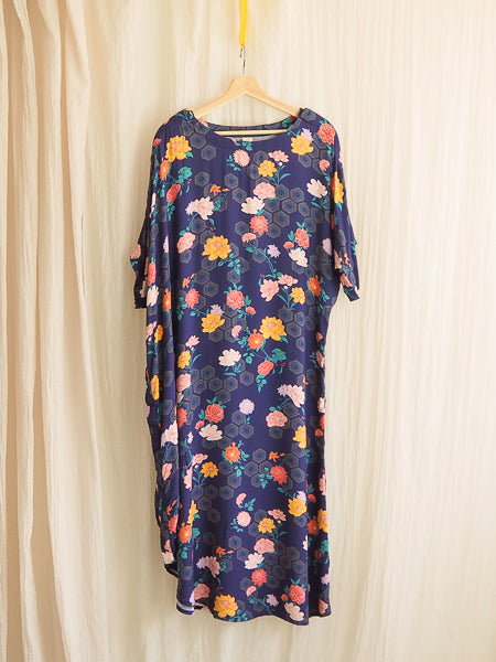 limonata adaptive dolce dress in navy geometrica floral and hexagon print hanging on a hanger 